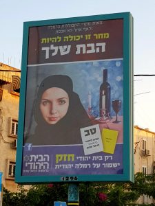  لافتة في اشوارع مدينة الرملة تظهر امرأة ترتدي الحجاب، مكتوب على البوستر: "فقط البيت اليهودي قوي من سيحافظ على الرملة يهودية"